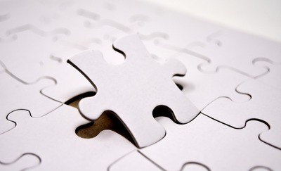 Interlocking jigsaw puzzle pieces on a flat surface, standing in for this week's theme of layers that have to fit together correctly — harnesses around models, retrieval around LLMs, judges around evaluation
