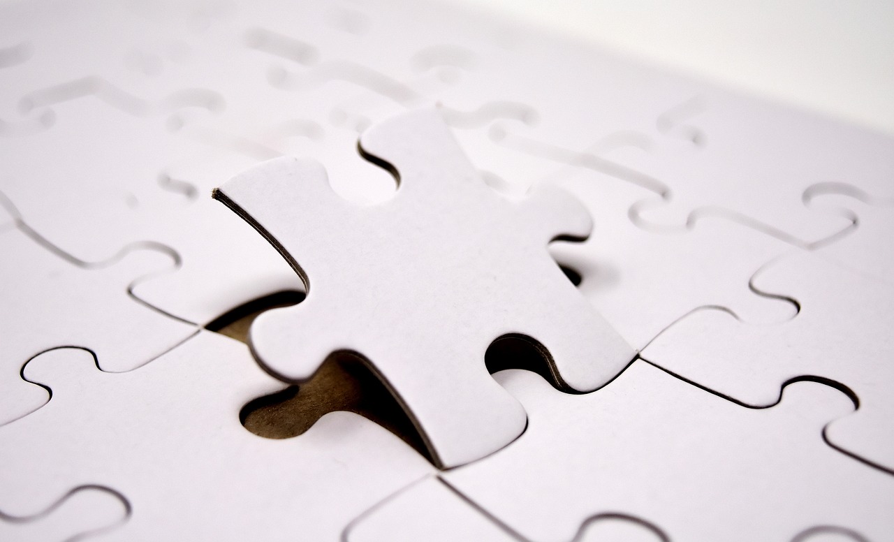 Interlocking jigsaw puzzle pieces on a flat surface, standing in for this week's theme of layers that have to fit together correctly — harnesses around models, retrieval around LLMs, judges around evaluation