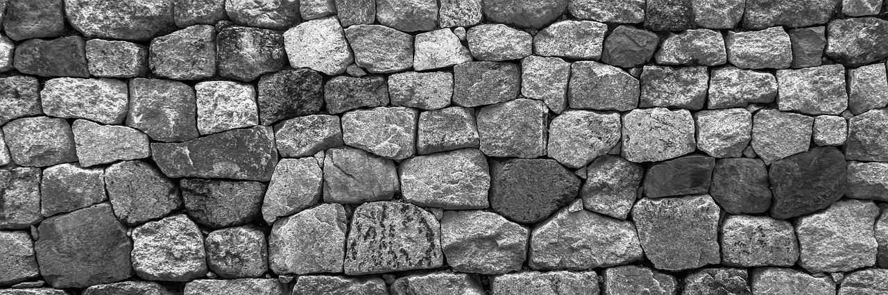 A dry-stone wall built from irregularly shaped rocks fitted tightly together, standing in for this week's theme of many small units — token vectors, skill catalogs — that only hold up when the structure connecting them is sound